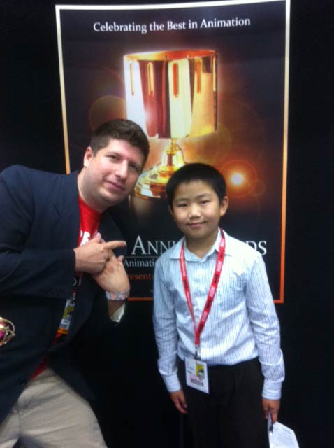 Kevin Sean Michaels and Perry Chen in front of a poster for the Annie Awards