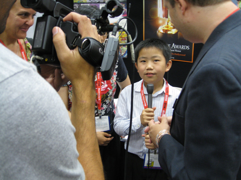 Perry Chen holding a microphone, film crew and others nearby